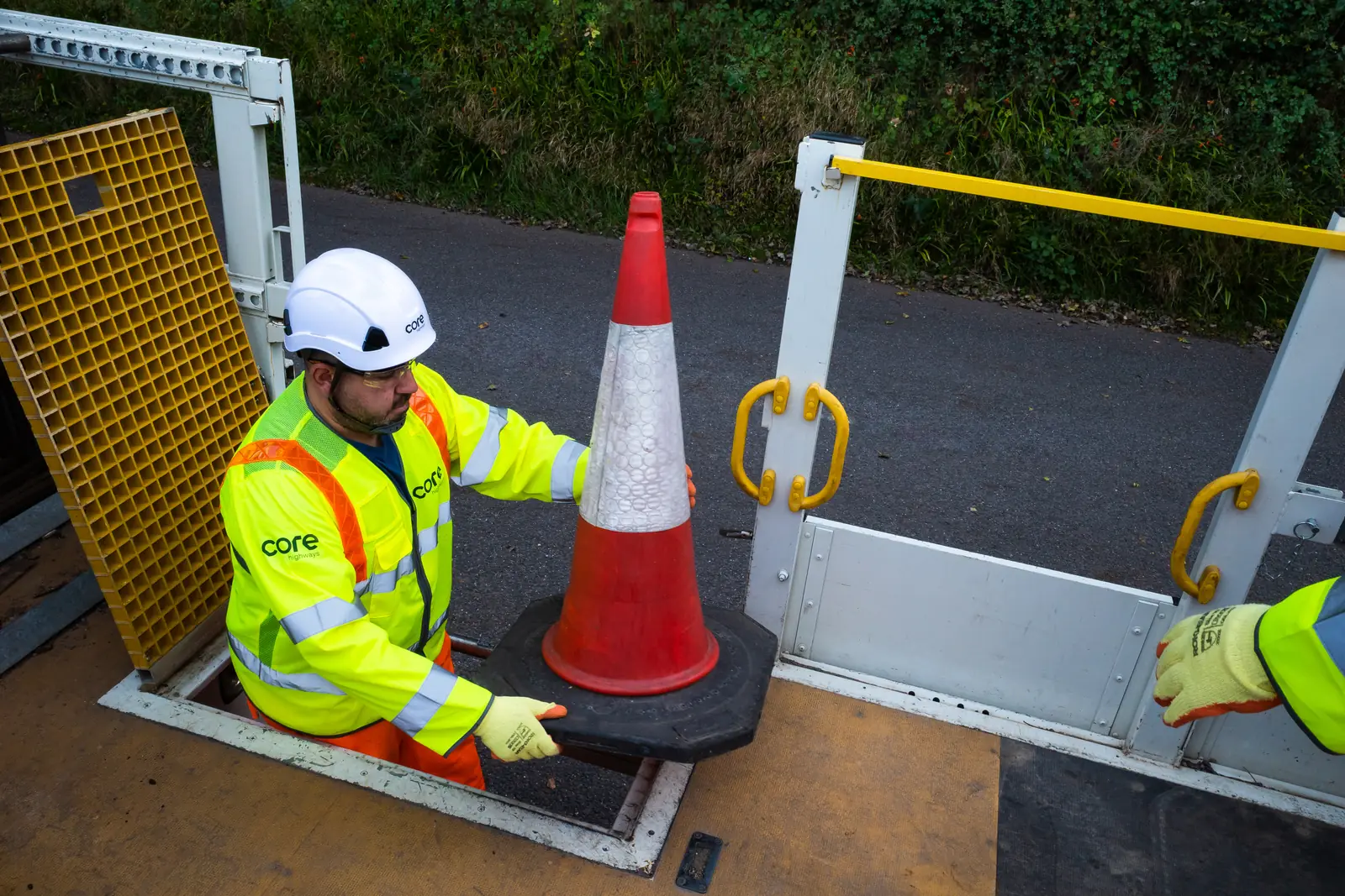 Core Highways operative loading a traffic cone onto a works vehicle